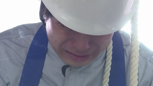 脸部特写 · 微笑 · 自然 · 正面站立 · 棕发 · 蓝色外套 · 铁丝网前