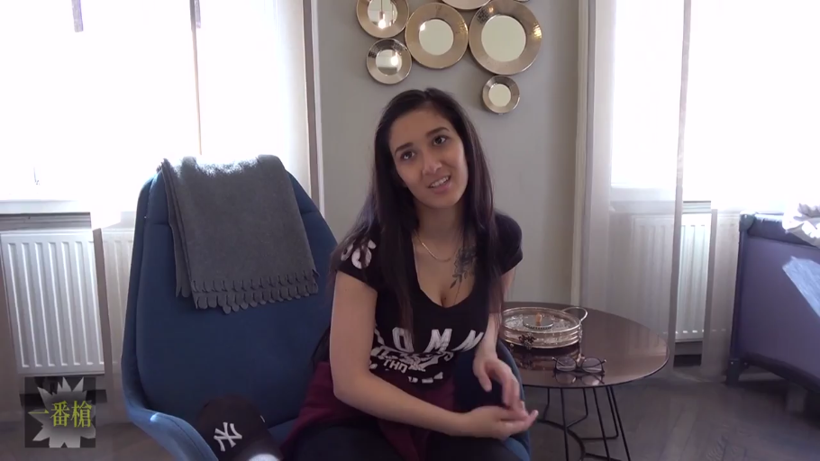 坐姿 · 中景 · 微笑 · 蓝色单人沙发 · 房间 · 黑色长裤 · 纹身 · 采访