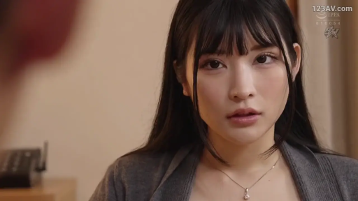 室内 · 面对镜头 · 灰色开衫 · 面部特写 · 注视 · 柔光 · 凝重 · 办公设备