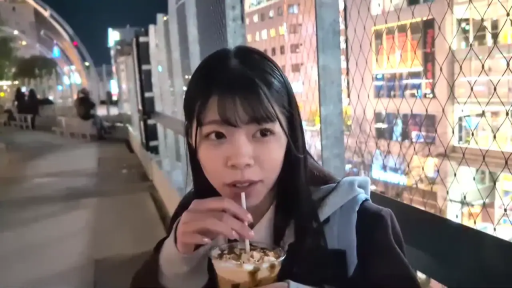 坐姿 · 自然 · 面部特写 · 夜景 · 户外街道 · 深色外套 · 喝饮料 · 饮料杯