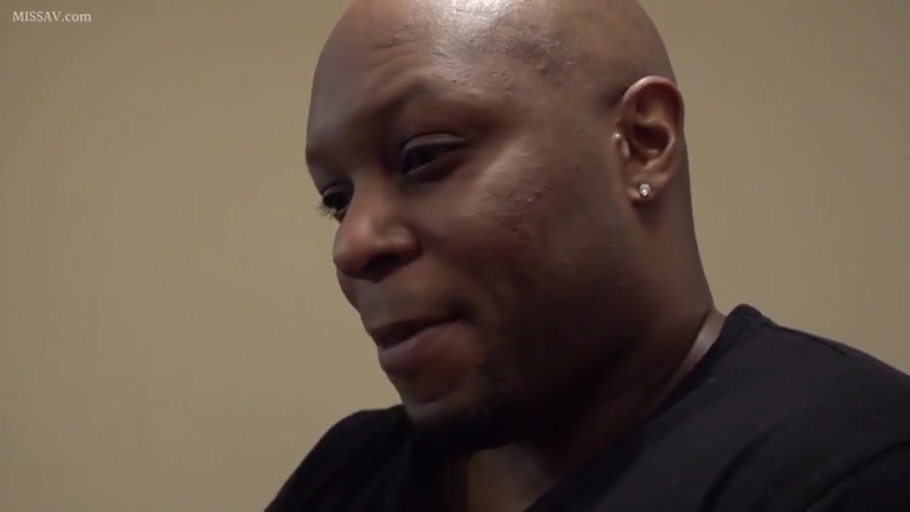 室内 · 侧面 · 脸部特写 · 微笑 · 注视 · 黑色T恤 · 黑人男性 · 耳钉