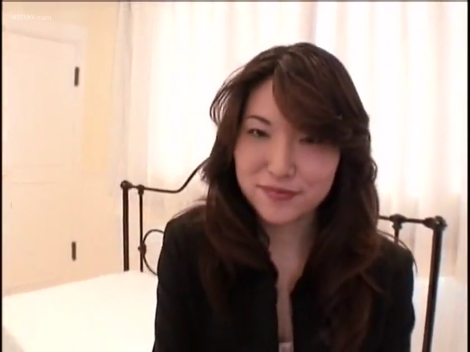 坐姿 · 卧室 · 微笑 · 床 · 面部特写 · 注视镜头 · 黑色外套 · 长发熟女