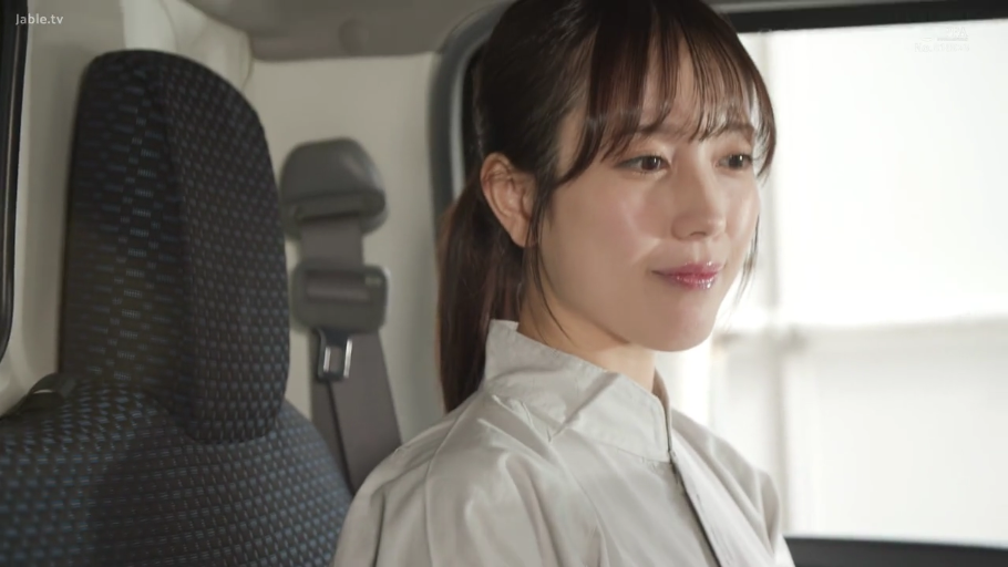 坐姿 · 脸部特写 · 安全带 · 侧头注视 · 平静微笑 · 职业女性 · 灰色工作服 · 货车驾驶室