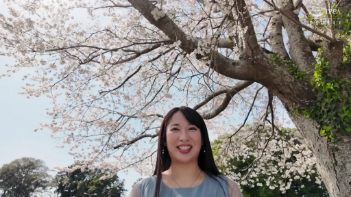 站立 · 面对镜头 · 半身特写 · 笑容 · 樱花树下 · 浅蓝色无袖上衣