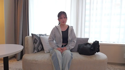 坐姿 · 中景 · 沙发 · 酒店房间 · 面对镜头 · 自然 · 灰色连帽卫衣