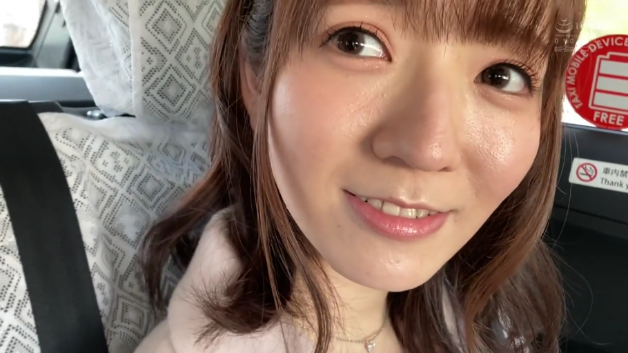 坐姿 · 女性 · 脸部特写 · 车内 · 看向镜头 · 禁烟标志 · 露齿微笑 · 淡粉色上衣