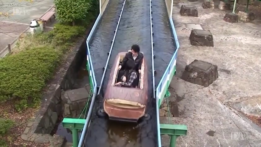 坐姿 · 远景 · 模糊 · 休闲外套 · 户外场景 · 游乐园水上设施 · 乘坐游乐设施 · 木桶船