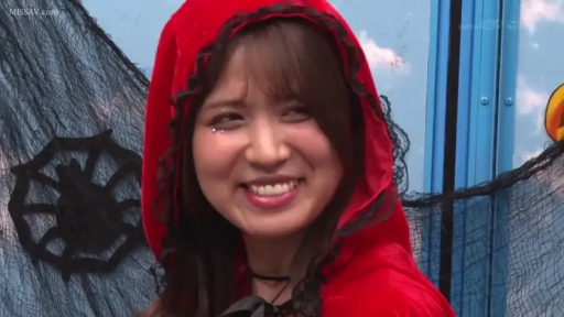 角色扮演 · 微笑 · 面部特写 · 开朗 · 红色连帽斗篷 · 室内万圣节场景 · 正面侧望 · 蜘蛛网装饰