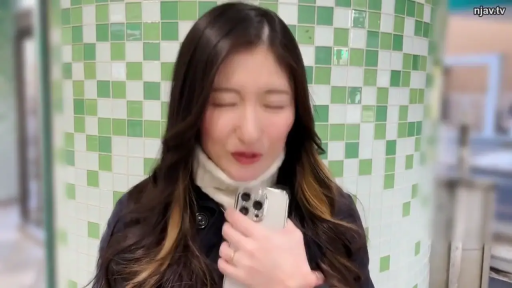 中景 · 站姿 · 微笑 · 手机 · 黑色大衣 · 长卷发 · 绿色方砖柱前 · 对着手机讲话