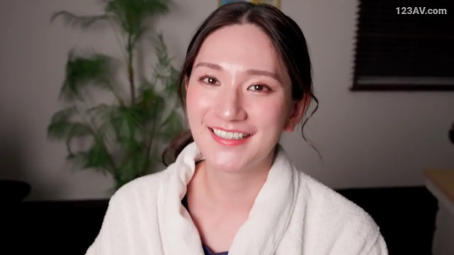 注視 · 笑容 · 头部特写 · 室内房间 · 正面坐姿 · 白色浴袍 · 背景植物 · 日本女性