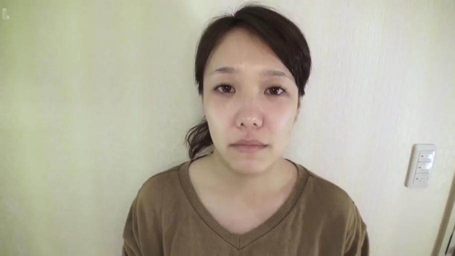 站立 · 凝视 · 棕色毛衣 · 头部特写 · 开关 · 无表情 · 墙边 · 素颜