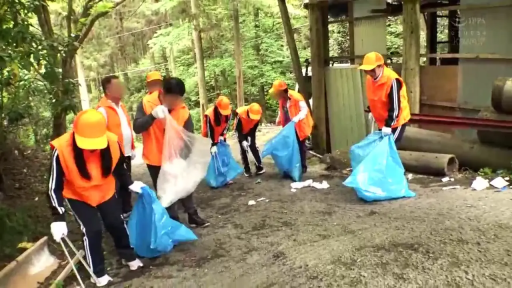 专注 · 弯腰 · 远景 · 户外 · 工作服 · 垃圾袋 · 多人活动 · 清理垃圾