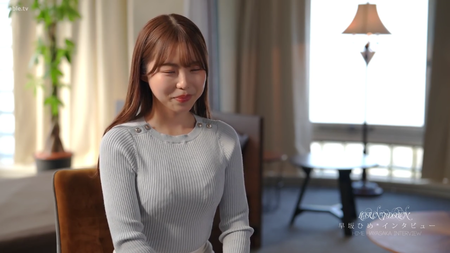 室内 · 坐姿 · 微笑 · 台灯 · 浅蓝色针织衫 · 胸部以上特写 · 采访谈话 · 柔和光线