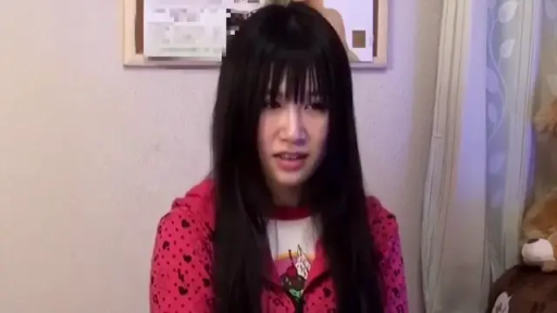 面部特写 · 室内房间 · 凝视镜头 · 正面坐姿 · 黑长直 · 背景海报 · 困惑表情 · 红色印花卫衣