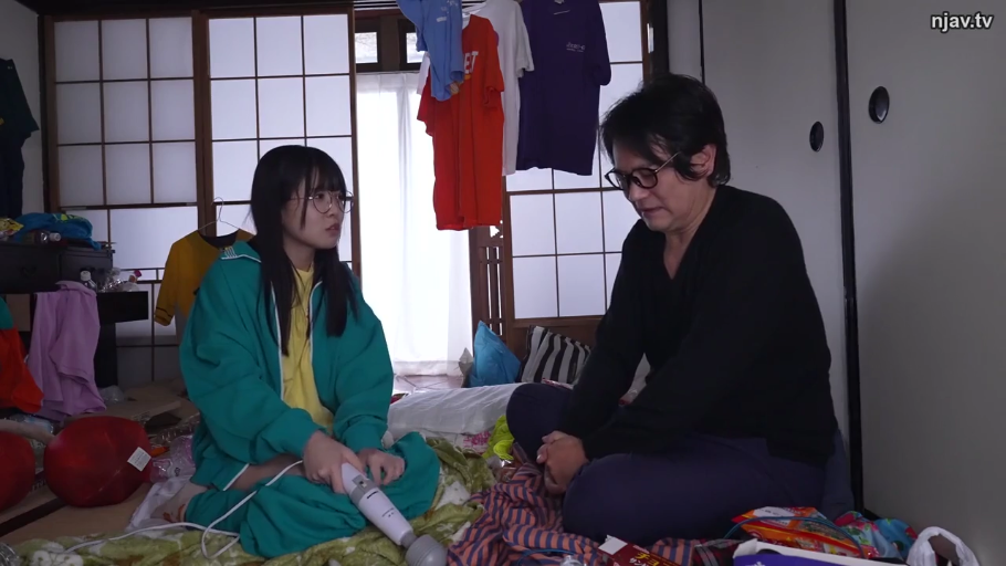 室内 · 真剣 · 中景 · 盘腿坐 · マッサージャー · 日式和室 · 緑色の運動服 · 持有按摩器交谈