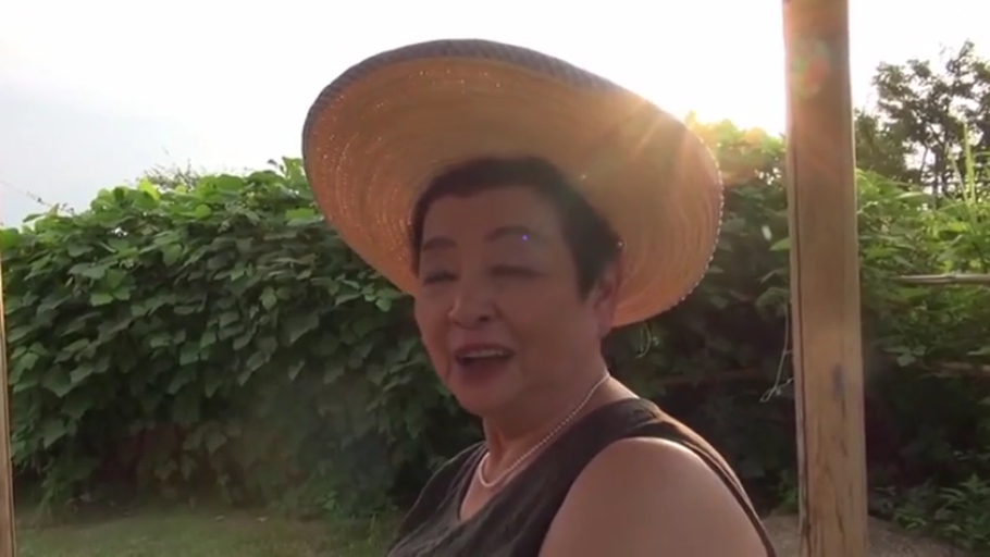 站姿 · 户外 · 熟女 · 头部特写 · 喜悦 · 言语 · 草帽 · 深色无袖衫