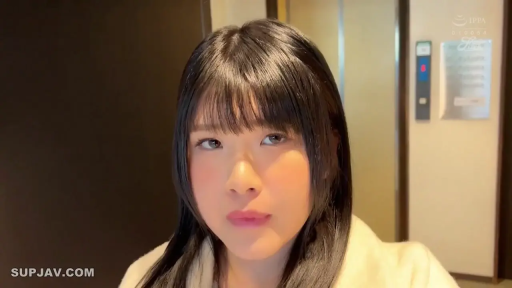 Standing Posture · 面部特写 · Eye contact · 白色外套 · 室内走廊 · 齐刘海 · 平静表情 · 指示牌