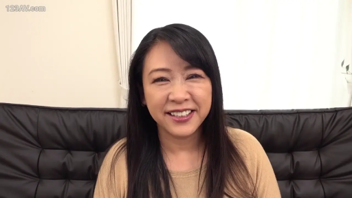 室内 · 坐姿 · 笑容 · 熟女 · 头部特写 · 黑色沙发 · 看镜头 · 浅褐色上衣