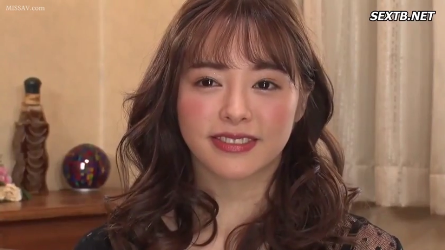 室內 · 面部特寫 · 注视镜头 · 正面坐姿 · 黑色蕾丝上衣 · 棕色卷发 · 微露齿笑 · 背景摆件