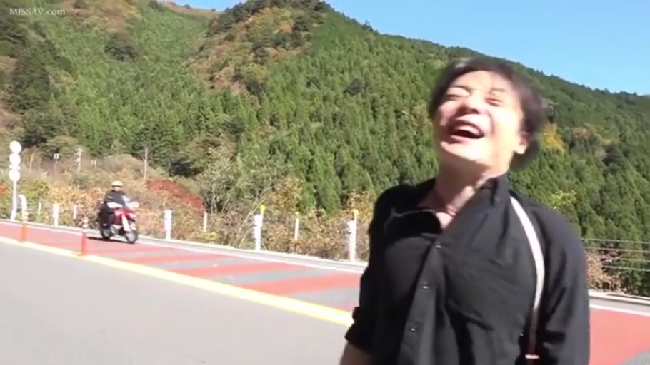 站立 · 上半身 · 户外 · 兴奋 · 大笑 · 黑色衬衫 · 摩托车 · 盘山公路