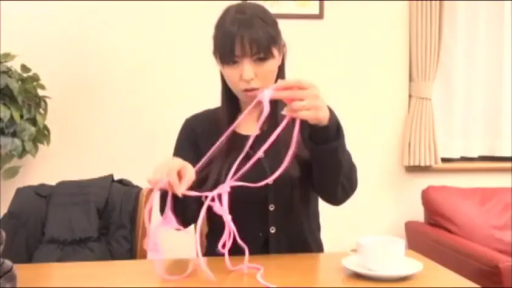 坐姿 · 专注 · 客厅 · 咖啡杯 · 黑色开衫 · 手部与物品 · 摆弄内衣绳索 · 解说演示