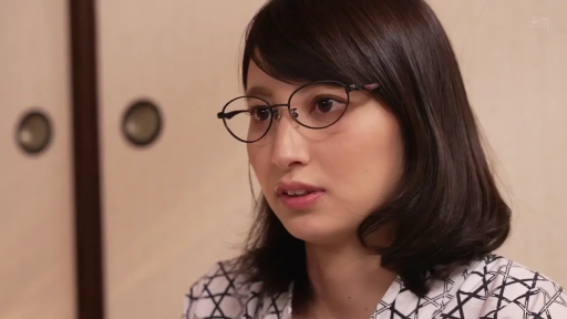 眼镜 · 面部特写 · 注视 · 沉稳 · 亚洲女性 · 日式室内 · 正面坐姿 · 几何图案上衣