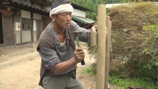 专注 · Medium shot · 半蹲 · 头巾 · Mature man · 锤子 · 户外农村 · 敲打木桩