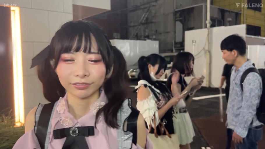 脸部特写 · 站立 · 微笑 · 街道 · 手机 · 开朗 · 时尚服饰 · 采访内容