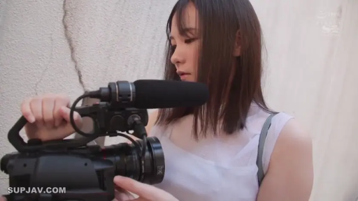 专注 · 半身 · 户外 · 长发 · 白色无袖上衣 · 侧身站立 · 专业摄像机 · 操作摄像机