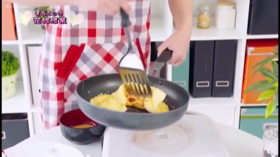 站立 · 厨房 · 手部特写 · 未露脸 · 居家风格 · 红白格纹围裙 · 烹饪蛋包饭 · 平底锅与锅铲