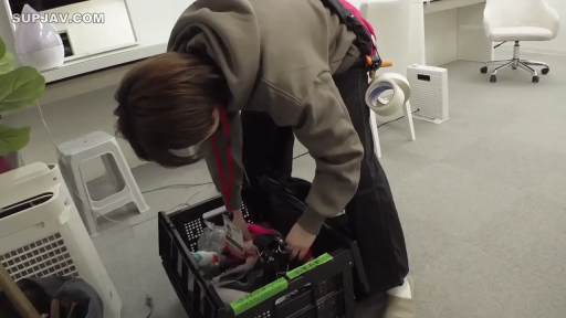 中景 · 弯腰 · 办公室内 · 棕色卫衣 · 整理物品 · 幕后拍摄 · 塑料筐