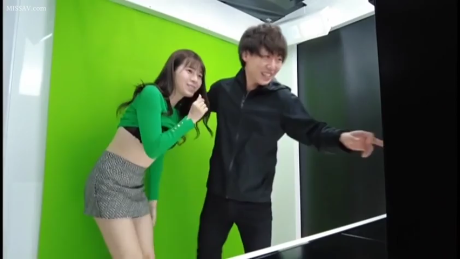 站立 · 中景 · 微笑 · 摄影棚 · 绿色长袖上衣 · 注视屏幕 · 绿幕 · 男女合影