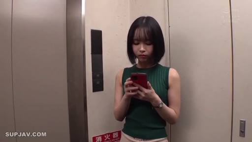 站立 · 平静 · 半身 · 看手机 · 短发 · 电梯 · 红色手机 · 绿色无袖针织衫