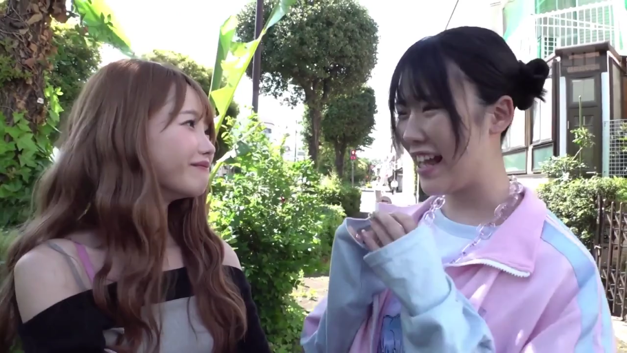 大笑 · 脸部特写 · 户外街道 · 运动衫 · 站立对视 · 开心笑容 · 塑料项链 · 街拍采访